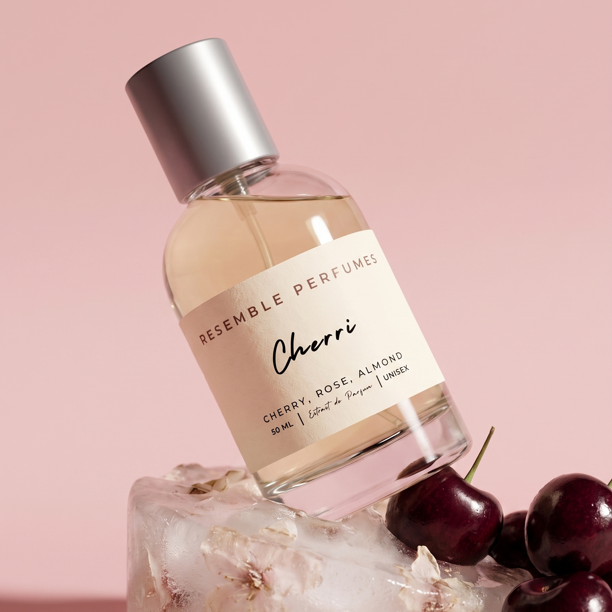 Cherri extrait de parfum by Resemble Perfumes resting on ice with black cherries on a pink background