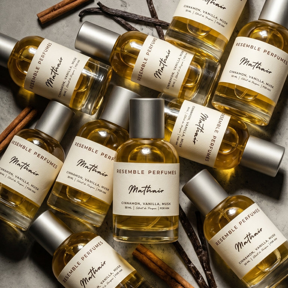 Several Mathair extrait de parfum bottles by Resemble Perfumes laid out with vanilla pods and cinnamon sticks