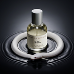 Ultra extrait de parfum by Resemble Perfumes standing in a ring of dark rippling water